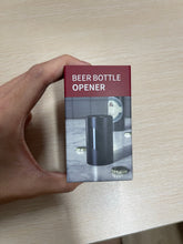 将图像加载到图库查看器中，electric beer bottle opener with box held in hand for size comparison
